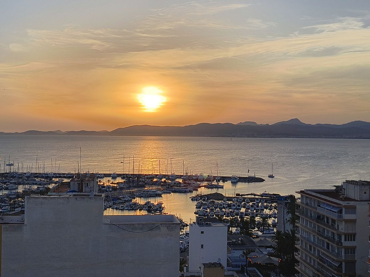 The sun setting over the marina and the mountains across the bay, the evening before the eclipse.